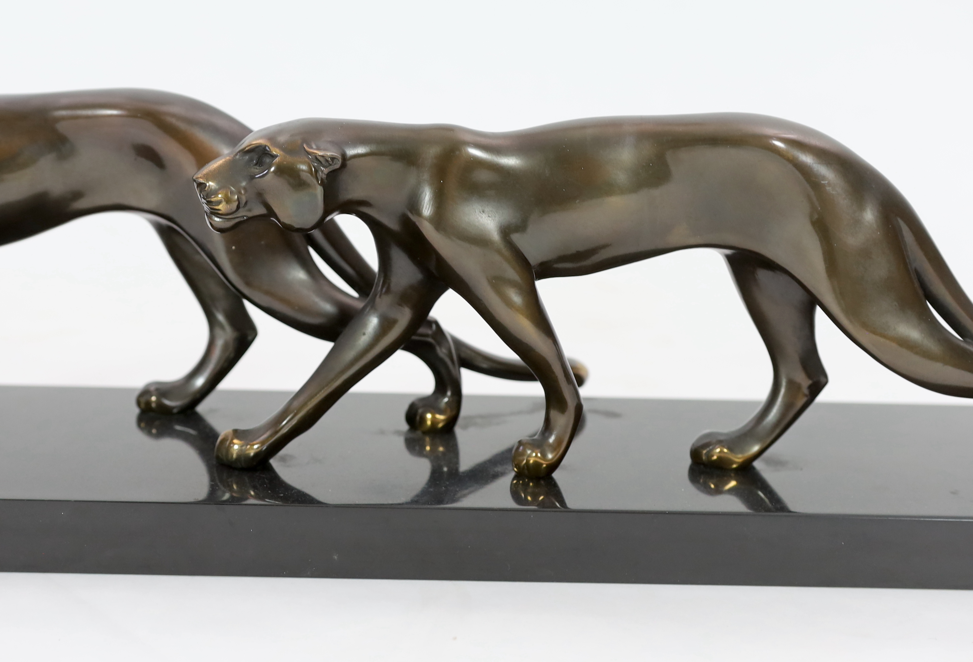 Marty Font, a French Art Deco bronzed and black marble group of two prowling panthers, 68cm wide, 18cm high